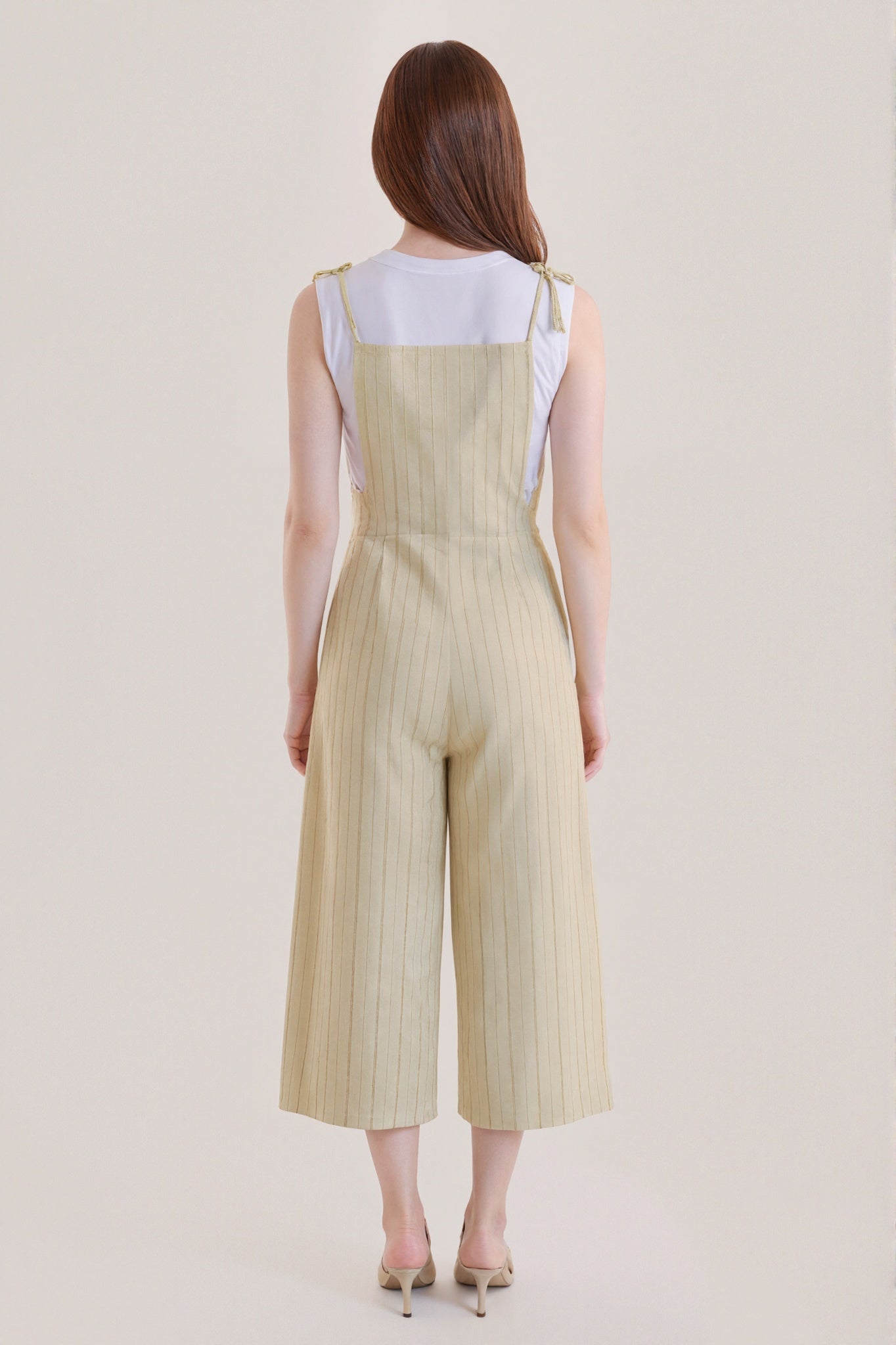 Sleeveless beige jumpsuit with subtle vertical stripes