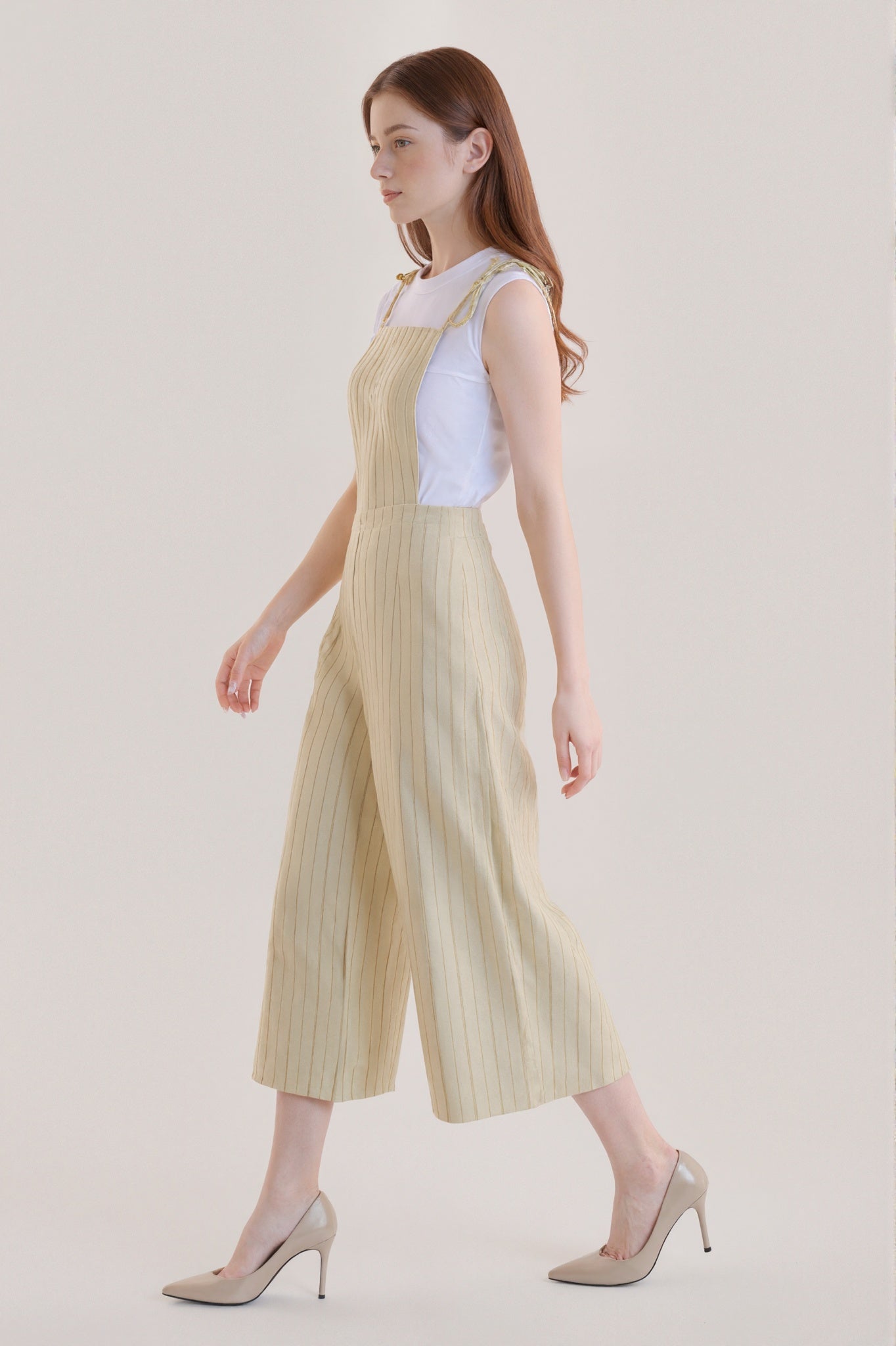 Sleeveless beige jumpsuit with subtle vertical stripes