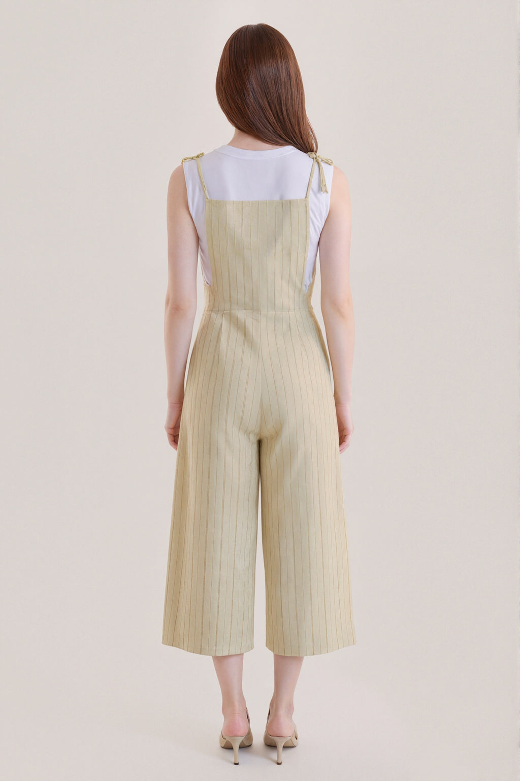 Sleeveless beige jumpsuit with subtle vertical stripes