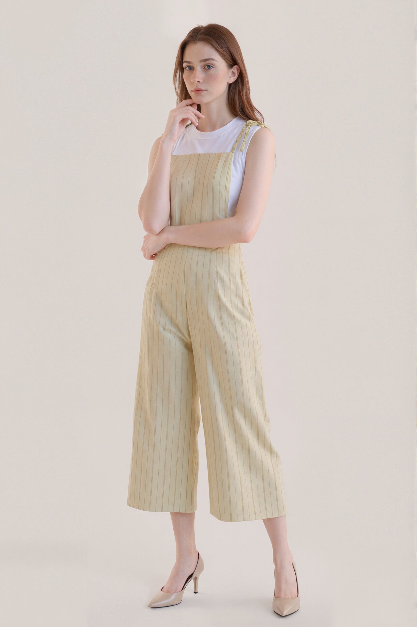 Sleeveless beige jumpsuit with subtle vertical stripes